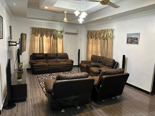 ein Wohnzimmer mit zwei Ledersofas und einer Couch in der Unterkunft BENJI'S VILLA in Kumasi
