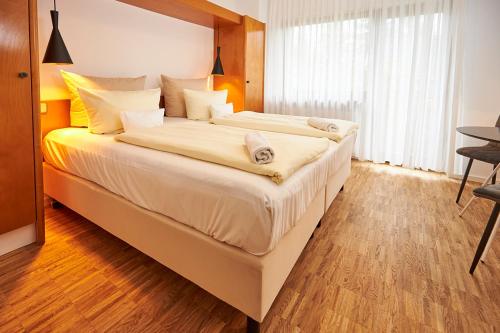 a bedroom with a large bed with white sheets at ERCK- Flair Hotel & Restaurant in Bad Schonborn