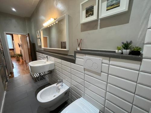 a bathroom with two sinks and a toilet and a mirror at Scala Apartments in Florence