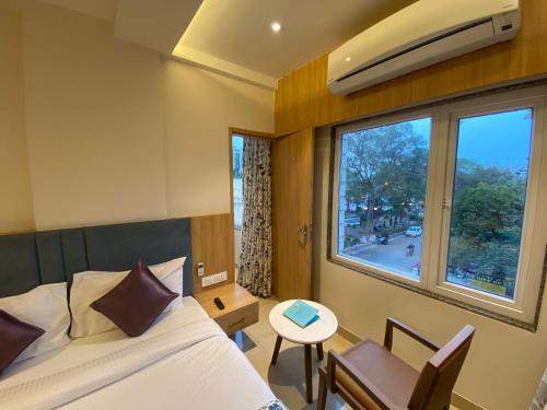 Un dormitorio con una cama y una ventana y un escritorio. en Hotel Mumbai House Express Udaipur, en Udaipur
