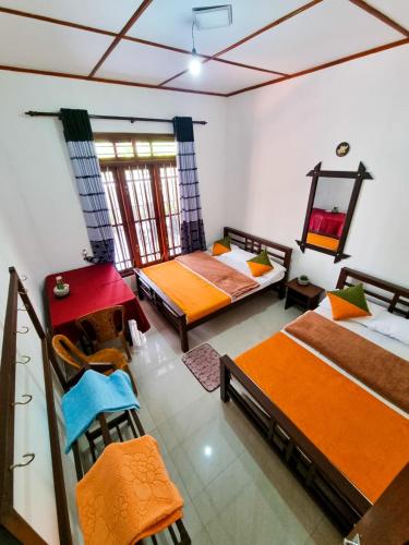 a room with two beds and chairs in it at Ivory Bloom Resort in Diyatalawa