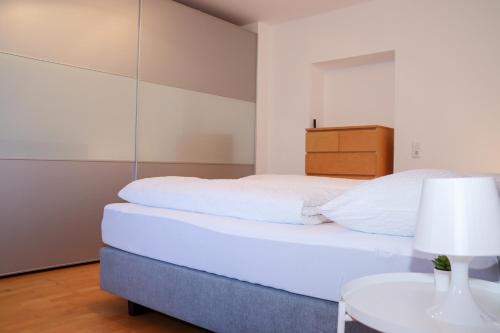 Appartement Bärhof في إنسبروك: غرفة نوم بسرير ابيض وطاولة
