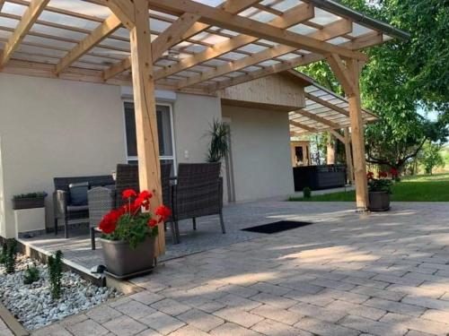 a patio with a wooden pergola and a table and chairs at Apróka Relax in Balatonlelle
