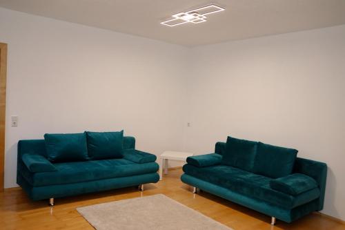 two green couches sitting in a living room at Appartement Bärhof in Innsbruck