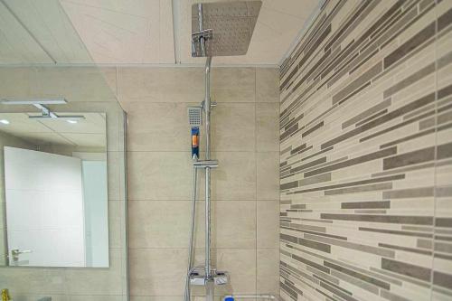 ein Bad mit einer Dusche und einem Spiegel in der Unterkunft New Apartamento centro de Torremolinos con Parking in Torremolinos