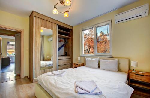 um quarto com uma grande cama branca e uma janela em 1BD Nest in the heart of a traditional Sofia em Sófia