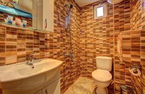 uma casa de banho com um WC, um lavatório e um chuveiro em 1BD Nest in the heart of a traditional Sofia em Sófia