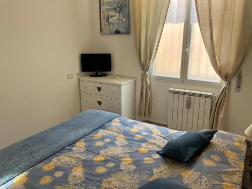 een slaapkamer met een bed, een televisie en een raam bij Aria di mare in Sanremo