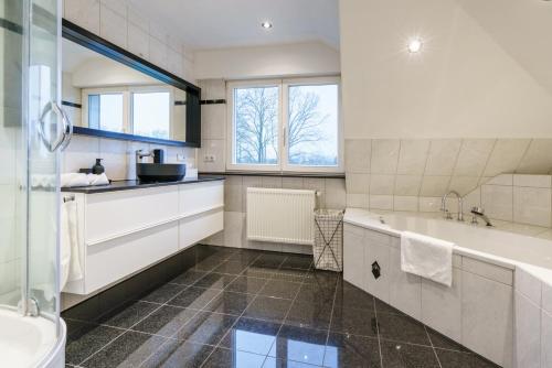 a bathroom with a tub and a sink at Huize van Neijenhoff in Schüttorf