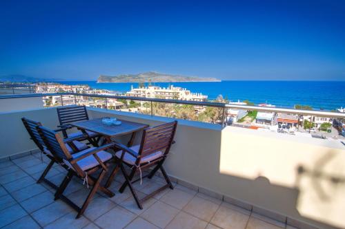 una mesa y sillas en un balcón con vistas al océano en Blue Villas, en Agia Marina de Nea Kydonia
