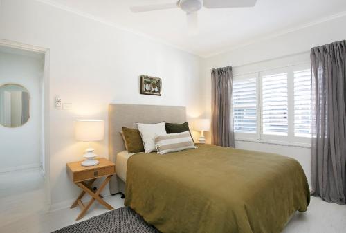 Un dormitorio con una cama grande y una ventana en Avalon Beachside Apartment, en Avalon
