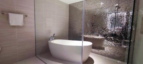 a bathroom with a tub and a glass shower at Star Sky Park KLCC in Kuala Lumpur