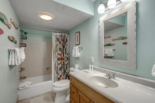 ein Badezimmer mit einem Waschbecken, einem WC und einem Spiegel in der Unterkunft Anchorage II B02 in Myrtle Beach
