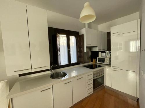 a kitchen with white cabinets and a sink at Palacio Santa Ursula in Toledo
