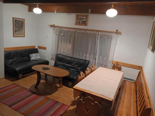 un soggiorno con divano e tavolo di Chata na Plantáži a Habovka