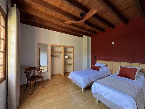 a bedroom with two beds and a ceiling fan at Gite la Tuilerie 46 in Tour-de-Faure