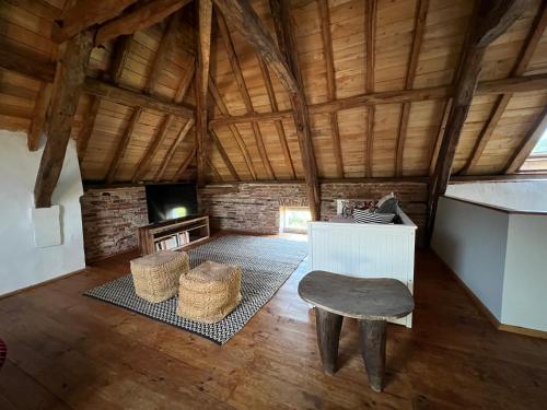 a large living room with a table and a chair at Gite la Tuilerie 46 in Tour-de-Faure