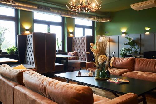 a living room with brown leather couches and a table at ERCK- Flair Hotel & Restaurant in Bad Schonborn