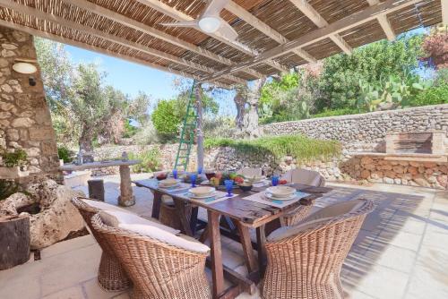 une table et des chaises en bois sur une terrasse dans l'établissement Tenuta Le Farcole by LoveSud, à Leuca