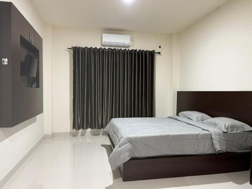 um quarto com uma cama grande e uma janela em De capitol Hotel Syariah em Patjinongong