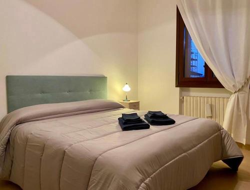a bedroom with a large bed with two towels on it at Casa Ester in Preganziol