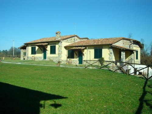 an old stone house with a green yard at Albergo La Foresteria in Bettolle