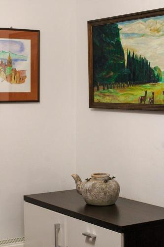 a vase sitting on a table in a room with paintings at Dobranić - Kuća za odmor in Sveti Martin na Muri