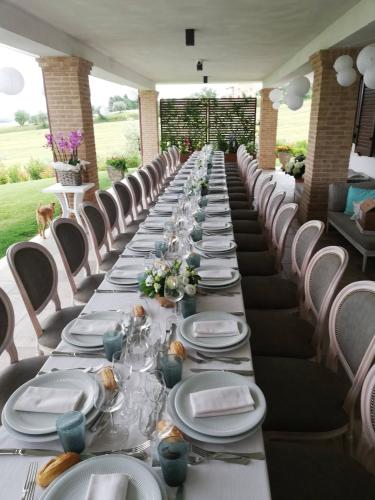a long table with white plates and flowers on it at Moresco Agriturismo in Moresco