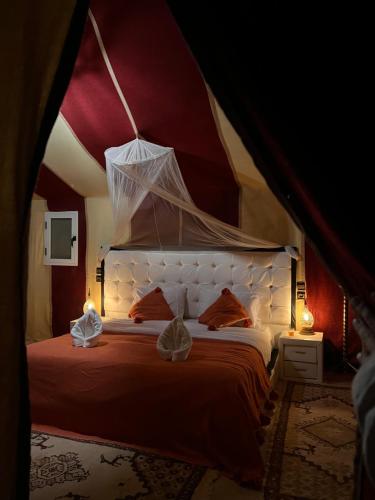 ein Schlafzimmer mit einem großen Bett in einem Zelt in der Unterkunft Kanz Erremal in Merzouga