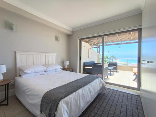 1 dormitorio con cama y vistas al océano en The Aqua - Sleeps 4 - Patio & Sea Views en Plettenberg Bay