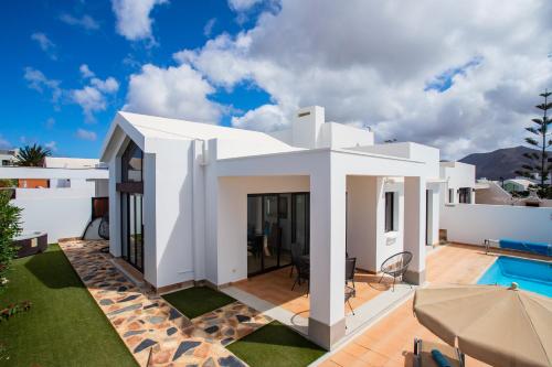 a white villa with a swimming pool at Casa Maurizio - Heated Pool, Hot Tub & Hammam in Playa Blanca