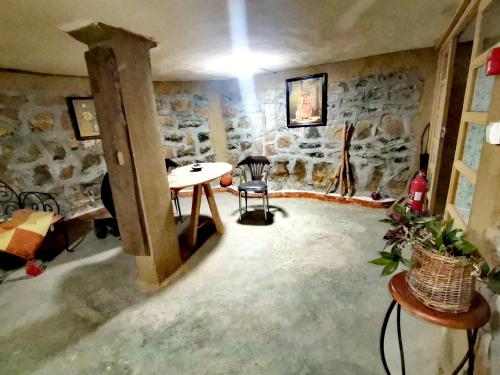 Habitación con mesa y pared de piedra. en Gîte Mourik en Aghbala