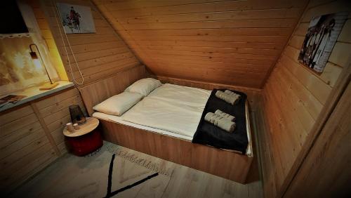 a small room with a bed in a wooden cabin at BIESZCZADZKA OSADA FILMOWA 