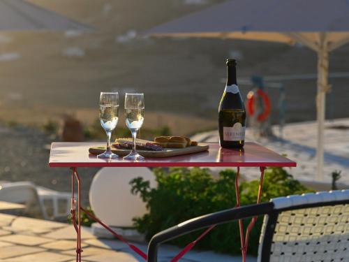 a table with a bottle of wine and two glasses at Dolce Vista - Sea View Apartments in Parikia