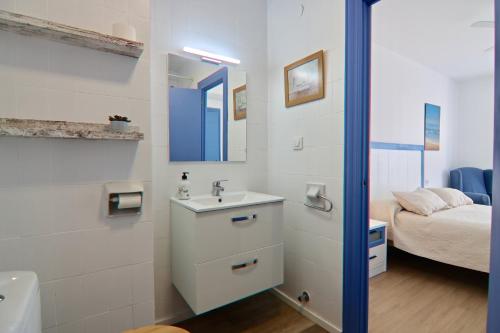 La salle de bains est pourvue d'un lavabo, d'un miroir et d'un lit. dans l'établissement AranPe PLAYA CÁDIZ, à Cadix