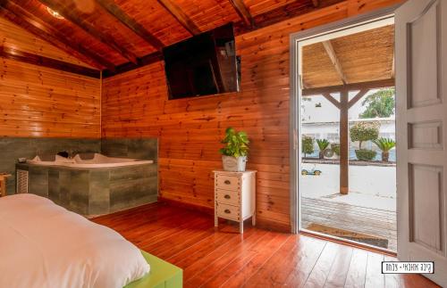 a bedroom with a bed and a sliding glass door at Atnachta BaGilboa in Addirim