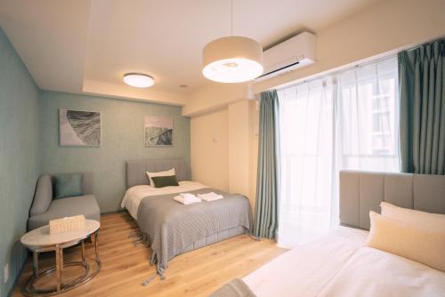 um quarto com 2 camas, uma mesa e uma janela em 谷町君HOTEL 心斎橋東32 em Osaka