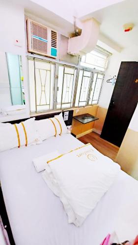 duże białe łóżko w pokoju z oknami w obiekcie SAAN INN w Hongkongu