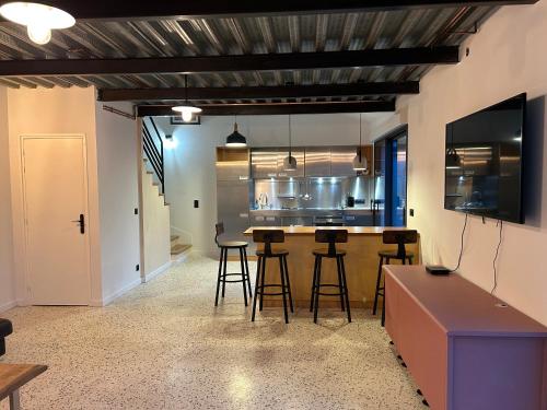 een keuken met een bar en krukken in een kamer bij Sara in Aulnay-sous-Bois