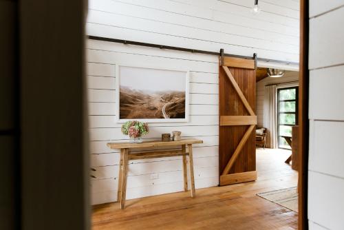 a barn door opens up to a room with a table at The Villa at Bali Garden Matakana in Omaha
