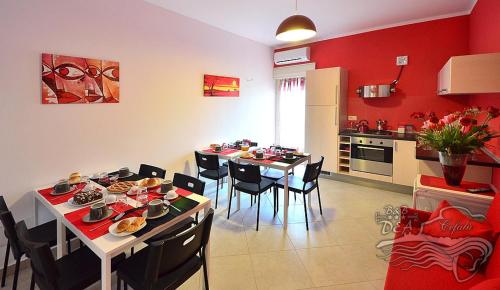 a kitchen and dining room with a table and chairs at B&B DEA in Cefalù