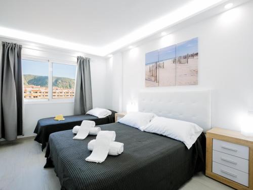 a bedroom with two beds with white towels on them at 5B Jardines Canarios sul Mar Smart Tv y Fibra in Los Cristianos