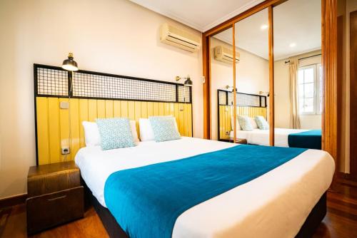 sypialnia z dużym łóżkiem i niebieskim kocem w obiekcie Smartr Madrid La Latina w Madrycie