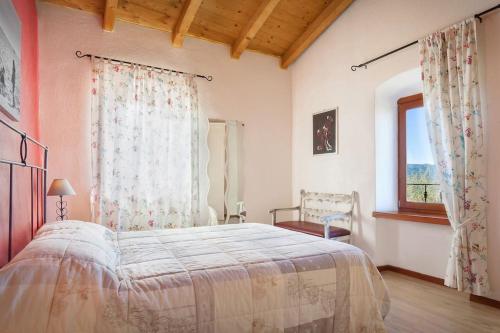Un dormitorio con una cama grande y una ventana en Casale Faigolo-Vista lago, en Navene