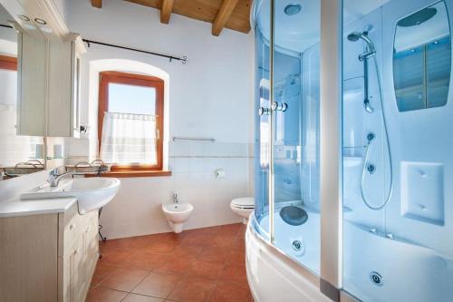 y baño con ducha, lavabo y aseo. en Casale Faigolo-Vista lago, en Navene