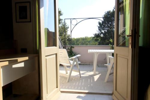 una porta aperta su un patio con tavolo e sedie di Il Villino Rosa a San Paolo Solbrito