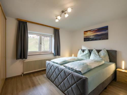 a bedroom with a large bed with a window at Haus Gletscherblick in Westendorf