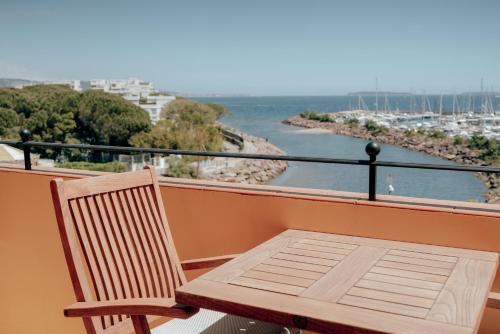 a balcony with a chair and a view of the water at Ermitage de l'Oasis & Spa - Cannes Mandelieu in Mandelieu-la-Napoule