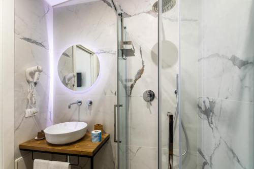 a bathroom with a sink and a shower with a mirror at Trisina Rooms in Avola