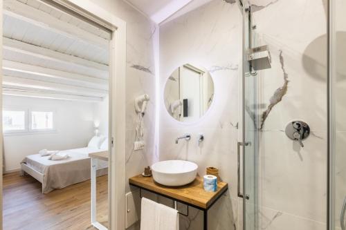 biała łazienka z umywalką i prysznicem w obiekcie Trisina Rooms w mieście Avola
